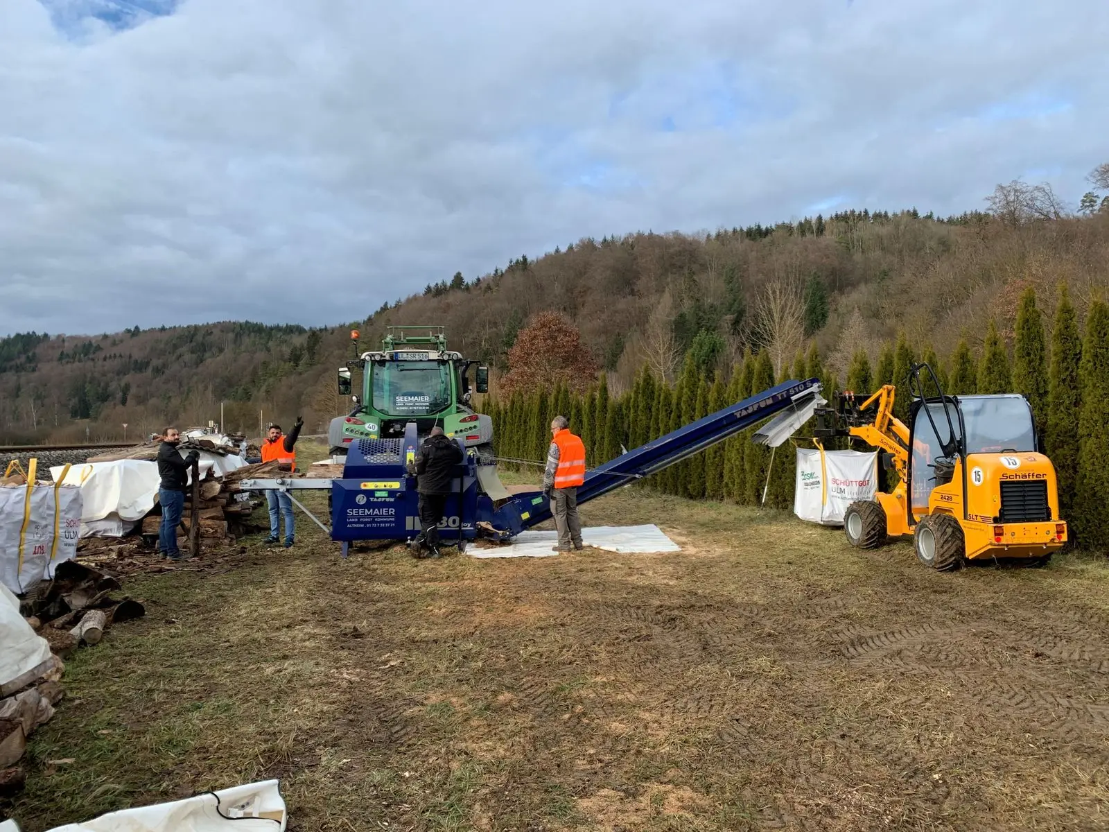 Holzaufbereitung mit Maschinen auf einer Wiese