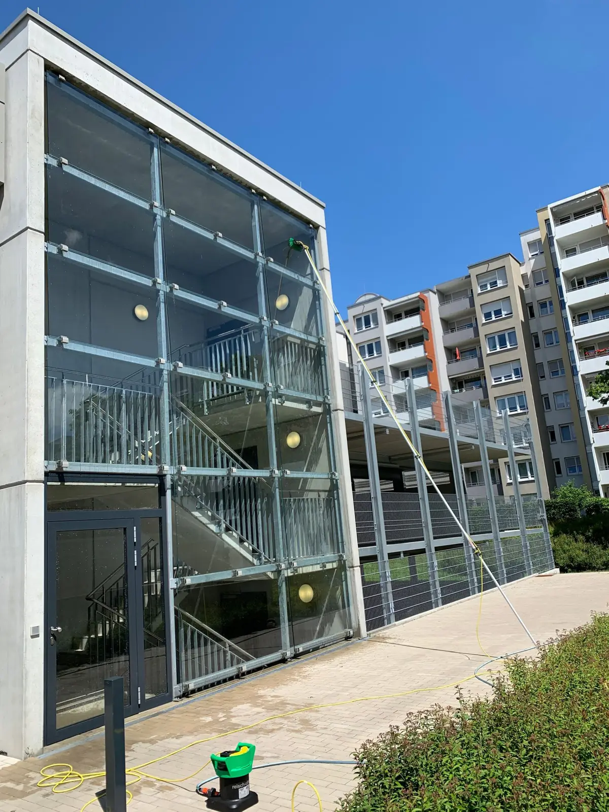 Glasfassade wird mit Teleskopstange gereinigt