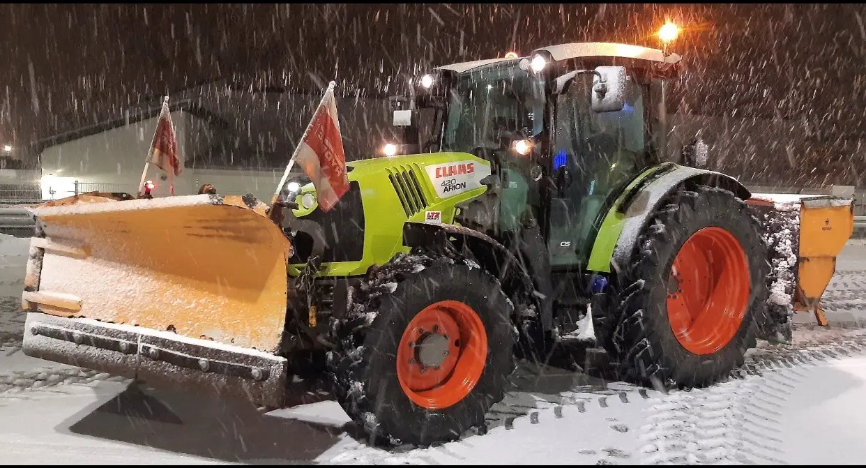 Traktor mit Räumschild beim nächtlichen Winterdienst